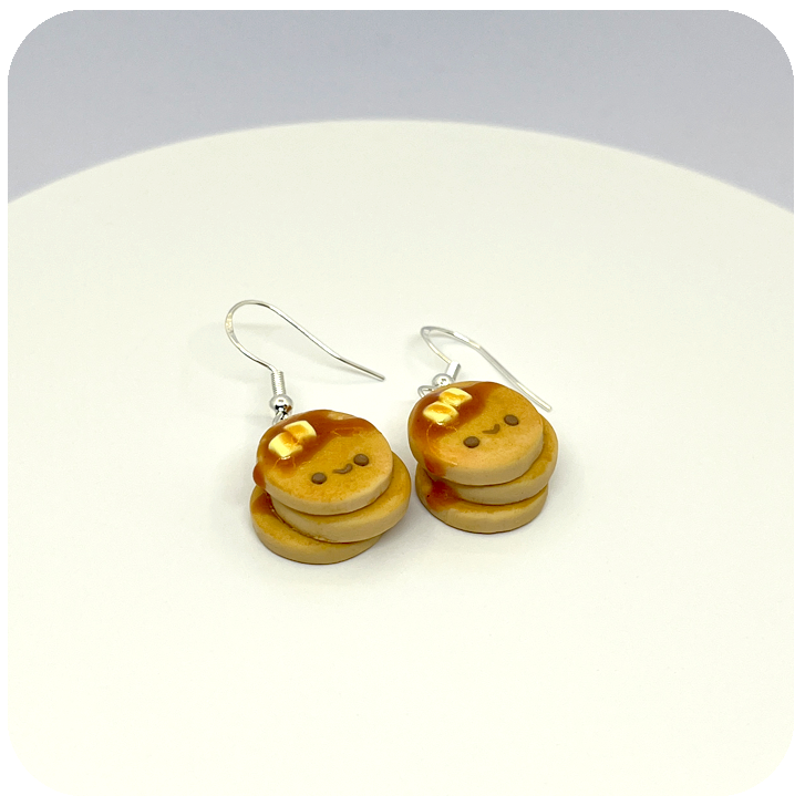 Close-up of kawaii pancake stack polymer clay earrings showing detailed butter square and maple syrup glaze.