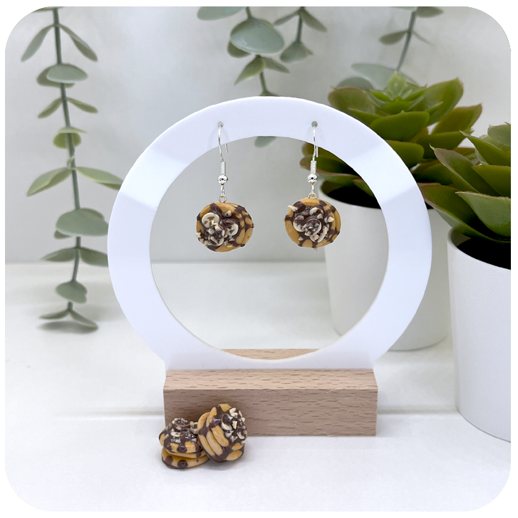 pancake earrings featuring chocolate sauce, banana slices and crushed nuts, handcrafted from polymer clay with realistic detail.