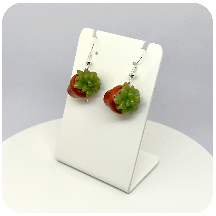 Close-up of miniature succulent polymer clay earrings showing realistic plant detail on sterling silver hooks.